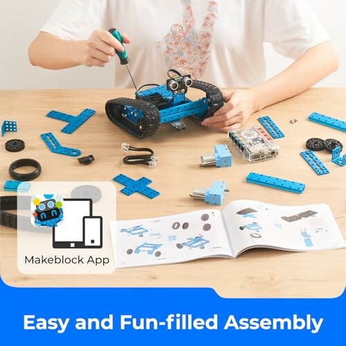 Person assembling a robotics kit with tools and manual.